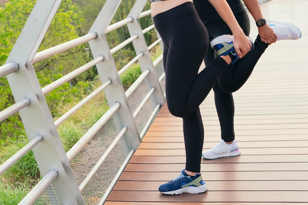 Dos mujeres que se estiran en el puente antes de correr.