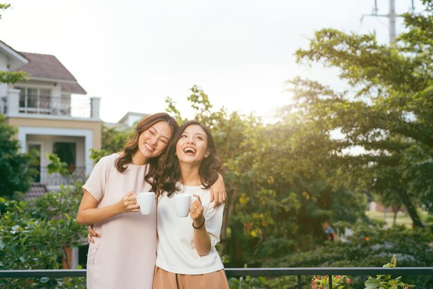 Dos mujeres, relajante, en, azotea, jardín, bebida, café