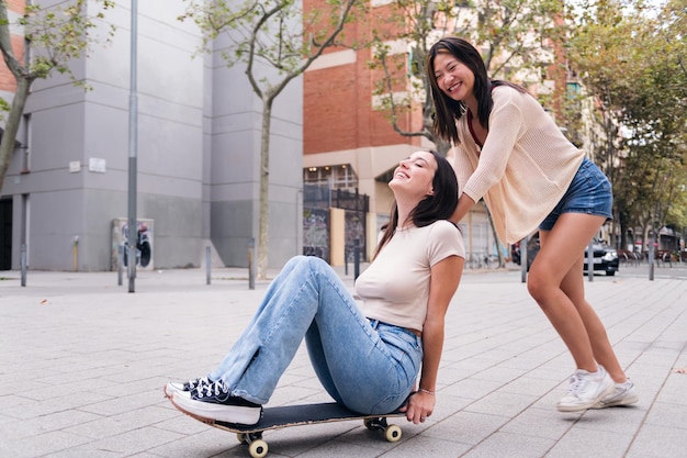 Dos mujeres riendo y divirtiéndose con un patín.