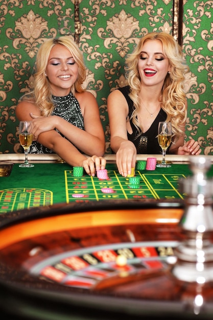 Dos mujeres rubias jugando a la ruleta en el casino