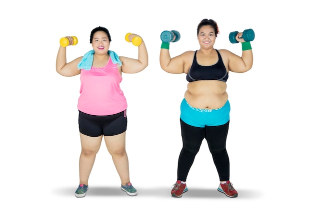 Dos mujeres con sobrepeso haciendo ejercicio con pesas