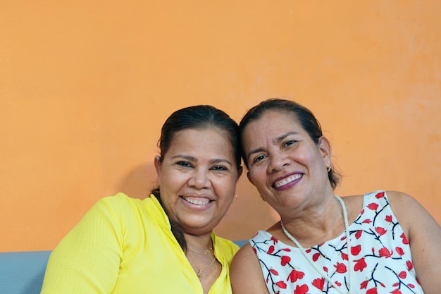 Dos mujeres sonriendo mientras está sentado en casa