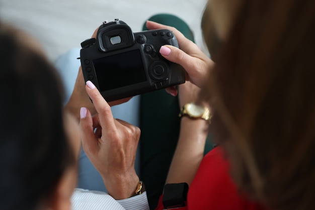 Foto dos mujeres sostienen la cámara en sus manos y presionan botones