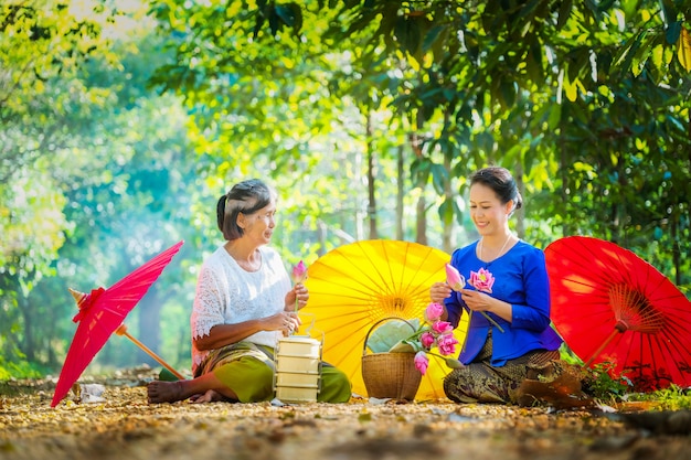 Dos mujeres tailandesas, dos personas doblaron loto rosa para ir al templo esta mañana.