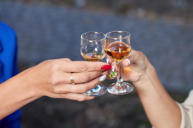 Dos mujeres tintinean vasos con alcohol