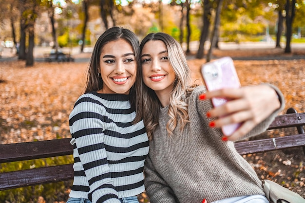 Dos mujeres tomando una foto con su teléfono celular