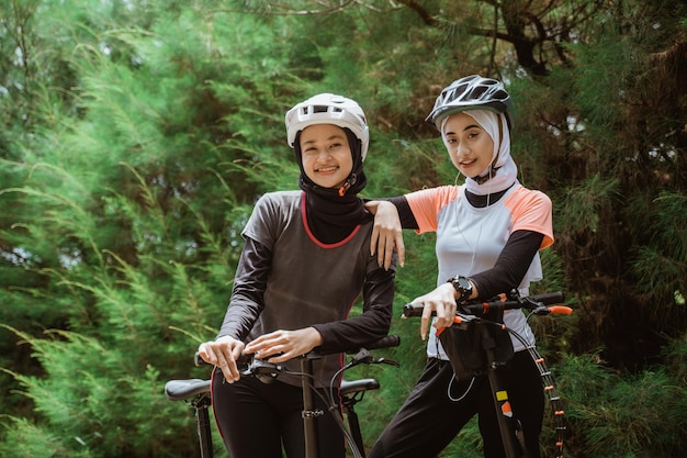 Dos mujeres con velo felices mientras andan en bicicleta juntas