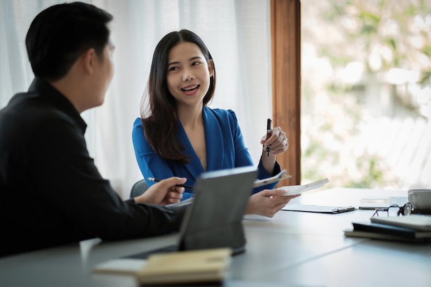 Foto dos negocios asiáticos hablar discutir con la planificación de un compañero de trabajo analizando tablas y gráficos de datos de documentos financieros en reunión y concepto de trabajo en equipo exitoso