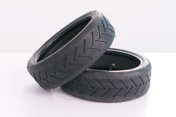 Dos neumáticos de scooter pequeños se colocan sobre un fondo blanco. Rueda de caucho. Reparación de piezas de neumáticos de vehículos negros.