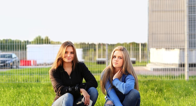 dos, niñas adolescentes, sentado, juntos, aire libre