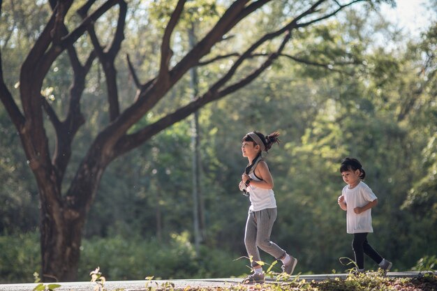 Dos niñas asiáticas divirtiéndose y corriendo juntas en el parque en tono de color vintage