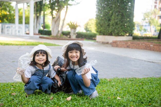 Dos niñas asiáticas son basura separada para reciclar