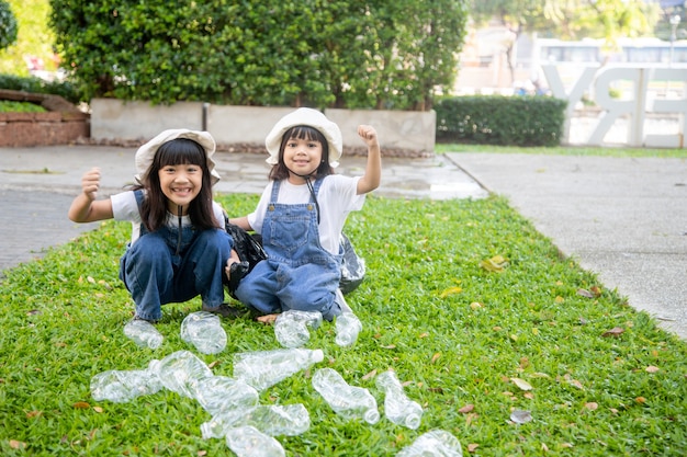 Dos niñas asiáticas son basura separada para reciclar