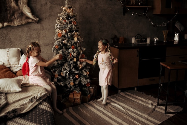 Dos niñas cerca del árbol de Navidad. Año nuevo