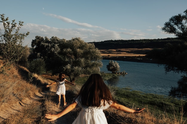 Dos niñas corriendo en la carretera cerca del río azul