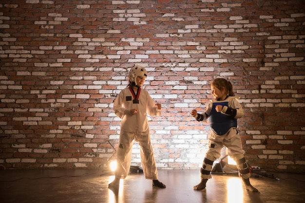 Dos niñas entrenando sus habilidades de karate de pie en la posición