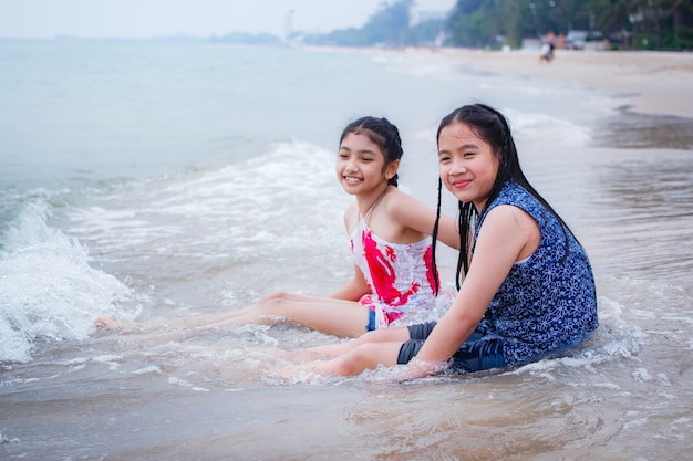 Dos niñas están en la playa.