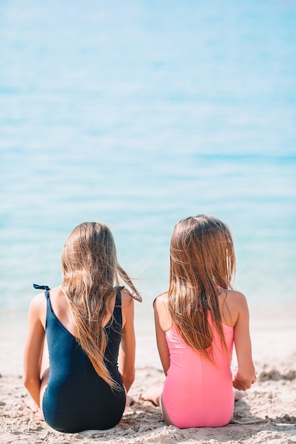 Dos niñas felices se divierten mucho en la playa tropical jugando juntos