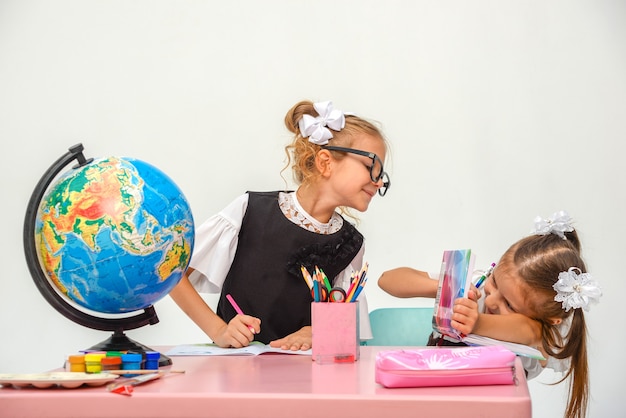 dos niñas felices estudian y escriben en clase aislar