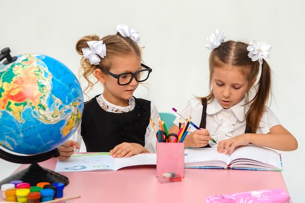 dos niñas felices pintando en clase