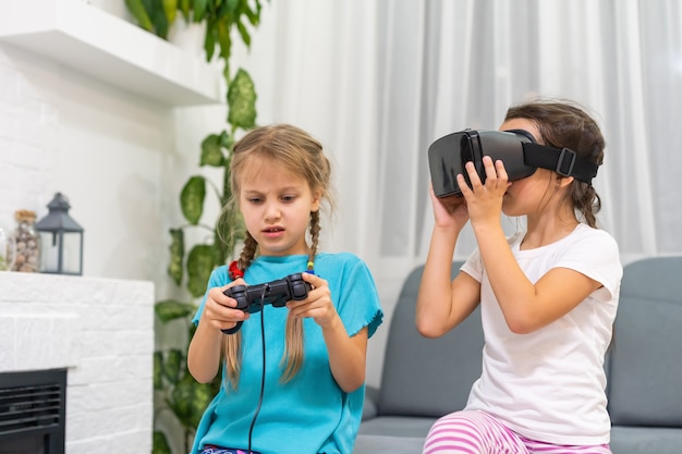 dos niñas con gafas de casco de realidad virtual. concepto de tecnologías modernas