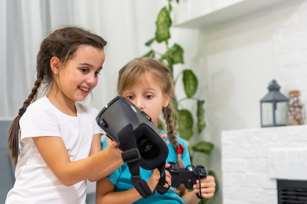 dos niñas con gafas de casco de realidad virtual. concepto de tecnologías modernas