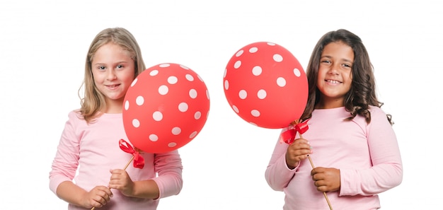 Dos niñas con globo rojo