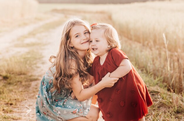 Dos niñas hermanas juegan en un campo de trigo