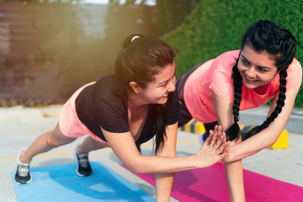 Dos niñas hispanas haciendo ejercicio en el parque