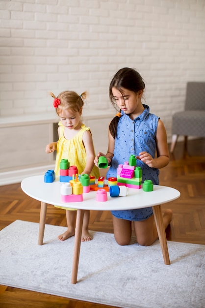 Dos niñas juegan con bloques en la habitación