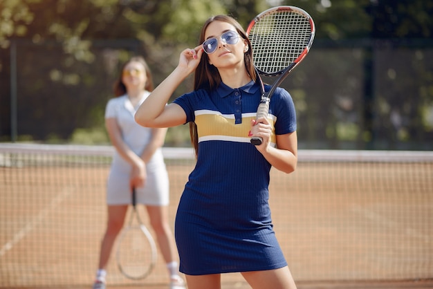 Dos niñas jugando en una cancha de tenis