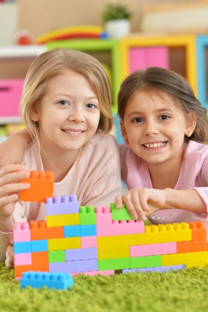 Dos niñas jugando con coloridos bloques de plástico