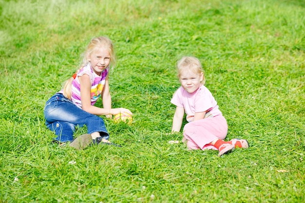 Dos niñas jugando en la hierba con la pelota