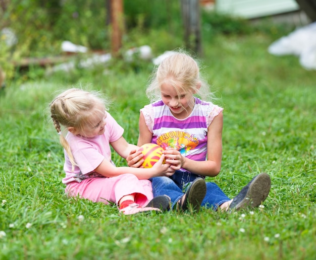 Dos niñas jugando en la hierba verde