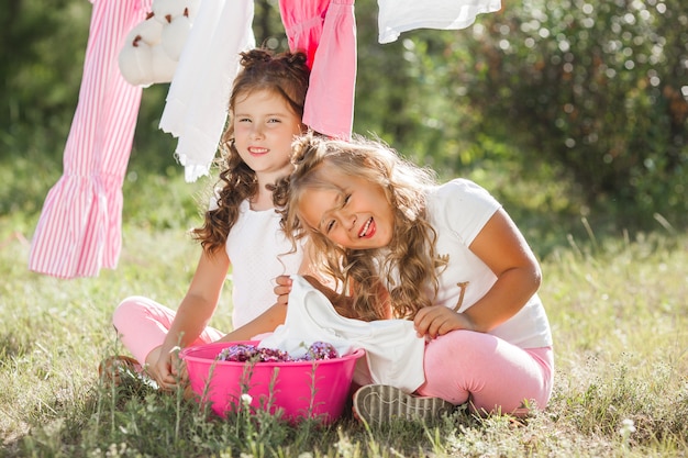 Foto dos niñas lavandas. hermanas haciendo quehaceres domésticos