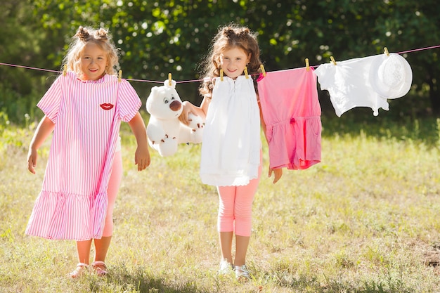 Dos niñas lavando. Hermanas haciendo las tareas del hogar