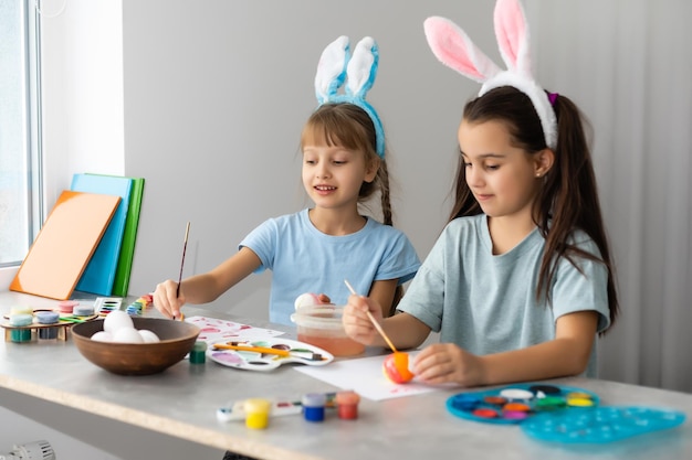 Dos niñas lindas pintando en huevos de Pascua