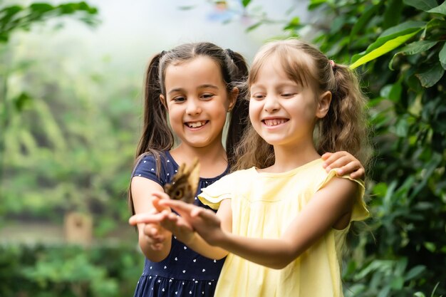 dos niñas con mariposas en un invernadero