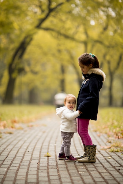 Dos niñas en el parque de otoño