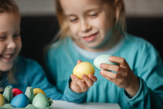 Foto dos niñas pequeñas y lindas con una sonrisa increíble jugando en un juego con huevos golpean huevos en una pelea