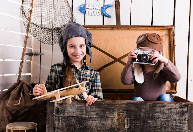 Foto dos niñas-pilotos en gran cofre de madera