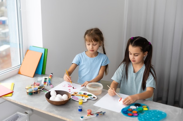 dos niñas con pintura de pincel sobre mesa, educación, acuarela, dibujo, concepto de creatividad.