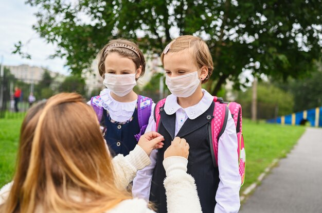 Dos niñas en el primer día de clases con máscaras protectoras.