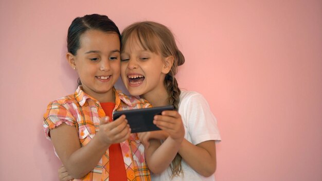 dos niñas tomando fotos con un teléfono inteligente