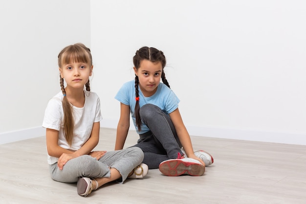 Dos niñas tristes, aisladas sobre blanco