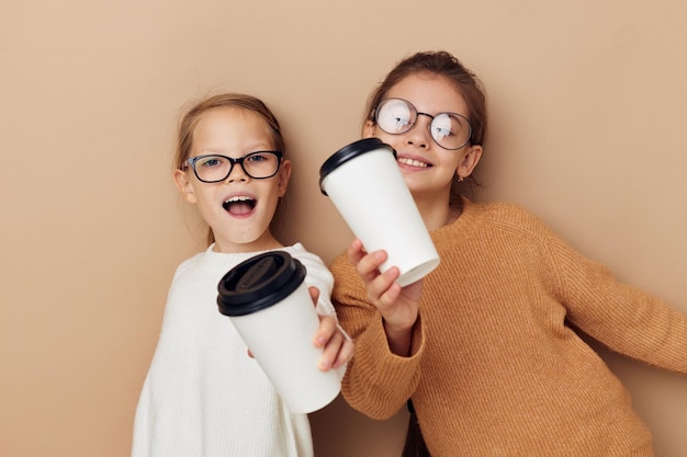 Dos niñas con vasos desechables en las manos.