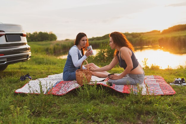 Dos niñas viajan en coche por las carreteras y se detienen para hacer un picnic en la carretera.