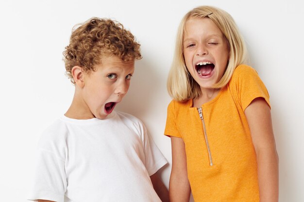 Dos niños alegres ropa casual posando emociones estudio aislado fondo inalterado. foto de alta calidad