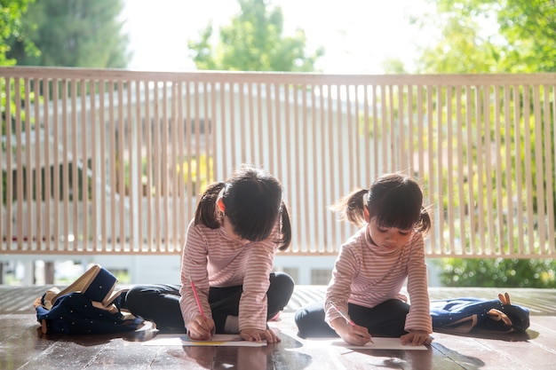 Dos niños asiáticos haciendo los deberes juntos en casa