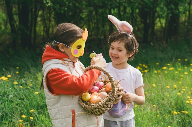 Dos niños buscan huevos de Pascua en un jardín de primavera Tradición de Pascua